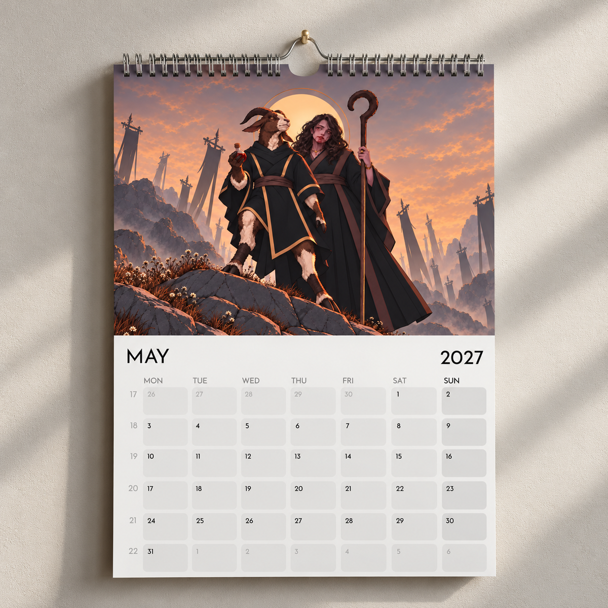 May 2027 calendar page showing a robed goat and a woman with a staff against a sunset.